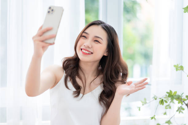  上野 キャバクラ・ガールズバー Young Asian woman using smartphone at home in the morning